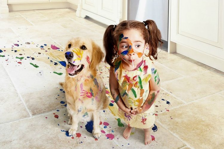 L'enfant et le chien sont tous deux couverts de peinture.