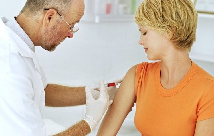 Le médecin fait une injection dans l'épaule