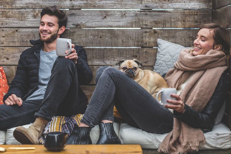 Un couple avec un chien buvant du café